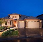 photo of brown colored house green lawn with dark blue sky